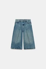 Bermuda de denim de tiro medio y corte wide leg, con diseño culotte, trabillas en la cintura y pliegues delanteros. Posee cinco bolsillos y cierre frontal con cremallera y botón.
