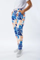 Pantalón babucha blanco con estampado de hojas en azul y naranja, con cintura elástica y cordón ajustable.
