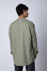 Camisa de lino color blanco con cuello mao y cierre frontal de botones. Presenta mangas largas con puños simples y un corte clásico.