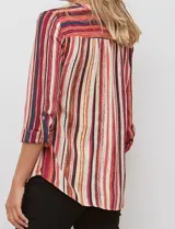 Blusa de gasa con estampado de rayas verticales en tonos rojos, naranjas y cremas. Presenta cuello mao con escote en V, abertura frontal con botones y mangas largas con presilla para regular el largo.