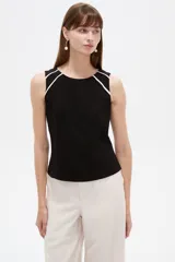 Musculosa blanca sin mangas de viscosa, con ajuste al cuerpo, cuello a la base y detalles de vivos.