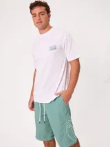 Remera negra de ajuste holgado con gran estampado gráfico en la espalda de temática tropical con una playa, palmeras y la inscripción "Welcome to Surfers Paradise".