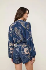 Short de tiro alto con cintura elastizada fruncida, bolsillos laterales y estampado integral de dragones y flores sobre base azul.