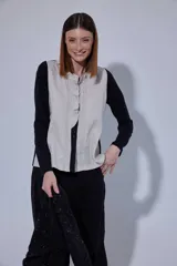 Blusa de estilo romántico con frente de lino y espalda y mangas de algodón con elastano. Presenta un diseño con mini volados en la pechera, cuello redondo y cierre frontal con botones.