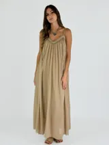 Vestido largo de corte holgado, con breteles finos y escote en V con detalle de costura decorativa. Confeccionado en tela liviana con caída fluida.