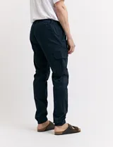 Pantalón de gabardina verde militar, corte cargo con bolsillos laterales con fuelle y tobillos ajustados con elástico.