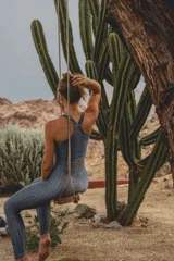 Top deportivo color azul grisáceo con estampado de patrón repetitivo. Presenta escote redondo al frente y espalda con tirantes cruzados en forma de Y, de largo medio.