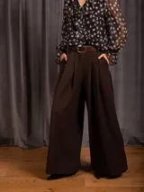 Pantalon tipo palazzo de corte amplio y tiro alto, con pinzas frontales, bolsillos laterales y cintura elástica.