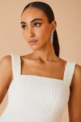 Vestido corto blanco de tejido texturizado, con breteles anchos y escote cuadrado.