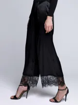 Pantalón negro de razo con terminación en encaje.