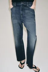 Jeans de tiro bajo con corte loose leg y largo tobillero. Presenta diseño de cinco bolsillos, cierre frontal con cremallera y botón, y acabado con efecto lavado.