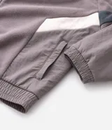 Buzo de fleece con cierre frontal completo y cuello alto. Presenta un diseño con recortes en tonos blanco y negro en las mangas y laterales, y cuenta con una estampa pequeña en el pecho.