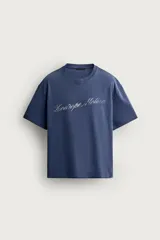 Remera boxy fit azul con efecto lavado, cuello redondo y manga corta, con estampa en el pecho.
