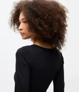 Body de manga larga color negro, con escote en V adornado con detalles de encaje. Presenta un diseño ajustado al cuerpo, confeccionado en una mezcla de algodón y elastano.