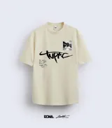 Remera color crema de algodón con estampado frontal de la firma de Tupac, una foto polaroid y una frase del artista.