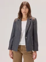 Blazer de denim estructurado con solapas clásicas, cierre frontal de un botón y bolsillos laterales con solapa. Presenta costuras visibles en contraste y un corte sastrero.