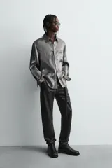 Pantalón slim fit confeccionado en piel, con diseño de cinco bolsillos, cierre frontal de cremallera y botón.