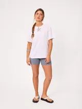 Remera lisa de manga corta, color blanco, con cuello redondo y calce holgado.