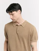 Remera color café de tejido de punto, con cuello polo y mangas cortas.