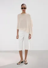 Poncho de punto con diseño de capa, asimétrico, cuello barco y manga tres cuartos.