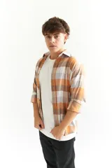 Camisa leñadora a cuadros color mostaza, blanco y gris, de manga larga y corte clásico.