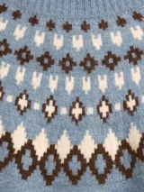 Buzo de punto con cuello alto, diseño estampado estilo fairisle con rayas horizontales y puntos en tonos tostado y blanco. Presenta mangas largas con puños acanalados y ruedo recto.