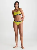 Parte de abajo de bikini color amarillo con textura de canalé y cintura elástica negra con logo de Calvin Klein en blanco.