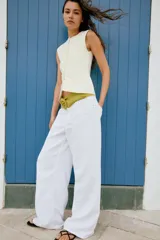 Top tipo chaleco confeccionado en hilatura con viscosa, con diseño de rayas horizontales en blanco y azul marino. Presenta cuello redondo, manga sisa y cierre frontal con botones.