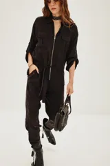 Enterito de estilo utilitario color negro, con cierre frontal, bolsillos en el pecho, mangas tres cuartos y lazo ajustable en la cintura.