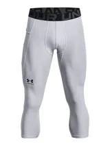 Calza deportiva de compresión tipo 3/4, color gris claro, con cintura elástica ancha negra con logo de la marca. Presenta paneles de malla para ventilación, bolsillo lateral y logo de Under Armour en la pierna.