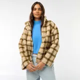 Chaqueta de tejido polar o efecto borreguito, color beige con estampado a cuadros en tono verde oliva. Presenta cuello alto con cierre de cremallera frontal.