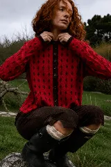 Cardigan reversible de punto con diseño de rombos pequeños, cuello redondo y cierre frontal con botones. Presenta un patrón bicolor en tonos bordó y rojo.