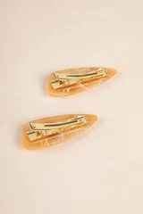 Par de broches triangulares color caramelo con diseño abstracto en blanco.