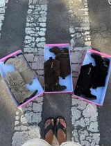 Botas de caña media confeccionadas en gamuza, con diseño holgado y detalle de flecos laterales con cadena metálica. Cuentan con suela plana y estilo western.
