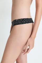 Bombacha tipo culotte less de color negro con estampado de lunares pequeños en color crema. Presenta un corte clásico con cobertura moderada.