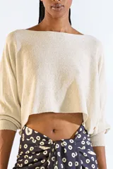 Sweater de escote bote confeccionado en tejido de punto con hilo metalizado, corte corto y mangas largas.
