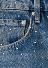 Jeans de denim azul de corte wide leg, con aplicación de pequeños tachas o strass plateados en toda la prenda.