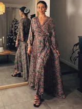 Kimono largo con estampado de cachemir en tonos azul, naranja y rosa. Tiene corte cruzado, mangas anchas y largo hasta los tobillos.