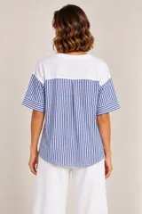 Remera blanca de algodón con mangas cortas a rayas azules y blancas, con aplique de flor en relieve de tela azul en el frente.