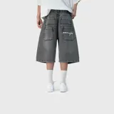 Bermuda baggy de denim color negro con efecto acid wash, corte holgado, bolsillos traseros múltiples y detalle de bordado en texto cursivo en uno de los bolsillos.