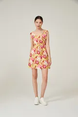 Vestido corto con estampado floral en tonos amarillo, rosa y rojo, con escote redondo, sin mangas y cintura elastizada con lazo.