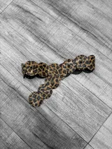 Cinto marrón con estampado animal print, apliques de tachas doradas y círculos de cuero unidos entre sí.