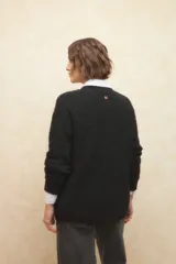 Polera beige de tejido de punto con cuello alto y mangas largas.