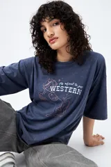 Remera azul de manga corta con estampa de caballo y texto "It's about to get WESTERN".