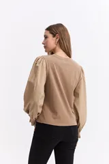 Remera de algodón con cuerpo liso y mangas largas abullonadas en popelina, con puños elásticos fruncidos.