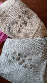 Saco de punto tejido a mano, con diseño envolvente y bordados artesanales de motivos celestiales como lunas y estrellas.