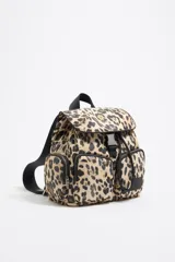 Mochila pequeña con estampado animal print, detalles en negro y múltiples bolsillos externos con cierre.