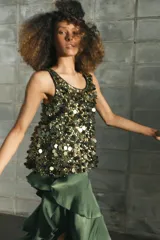 Falda midi de tiro medio color verde oscuro, confeccionada en tejido satinado con volantes en cascada y cierre lateral con cremallera oculta.