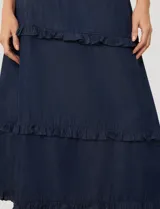 Pollera larga de lyocell en color azul, con diseño de paneles escalonados y volados en cada costura. Presenta cintura elástica fruncida para mayor comodidad.