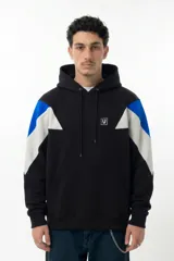 Hoodie oversize de algodón, con diseño de paneles en color negro, blanco y azul en hombros y mangas. Presenta capucha con cordones ajustables, bolsillo frontal tipo canguro y logo bordado en el pecho.